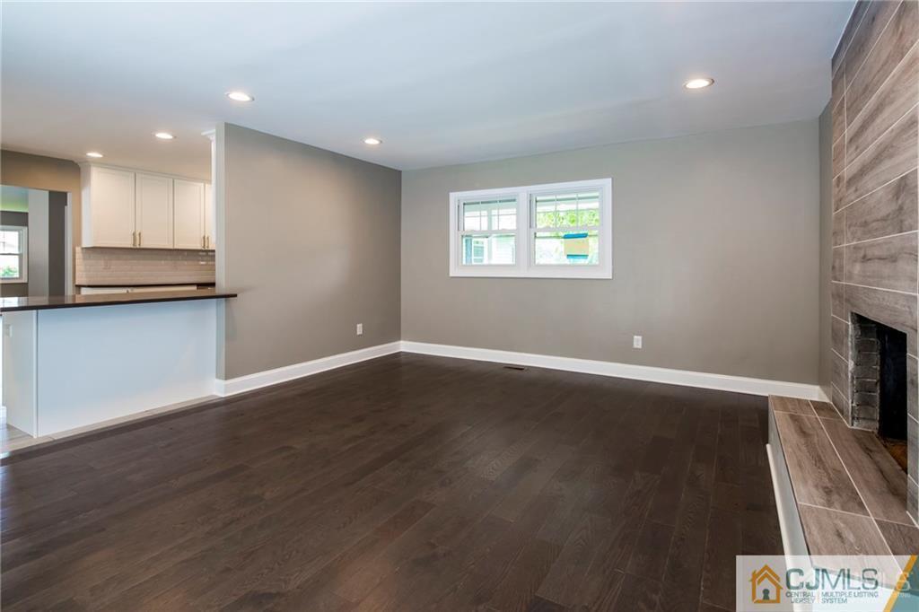 9 Edgewood Road Old Bridge, NJ 07747 - Photo 21 of 35 an empty room with wooden floor and a kitchen