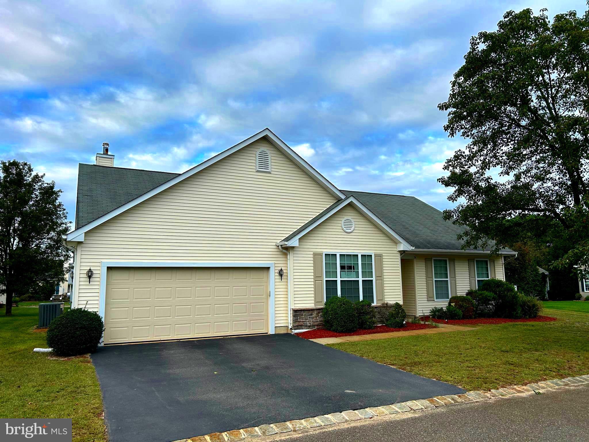 a front view of a house with a garden and pathway