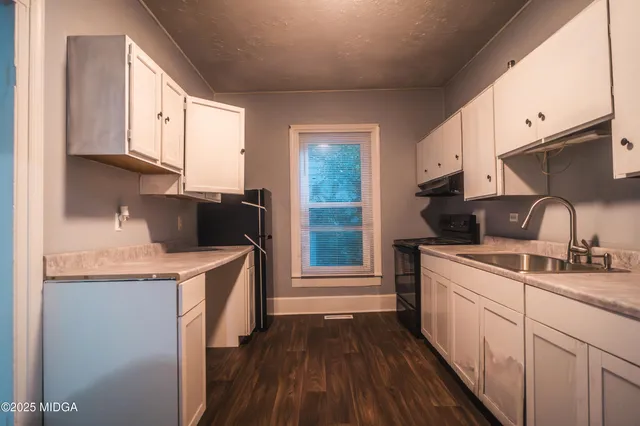 a kitchen with a sink a stove and cabinets