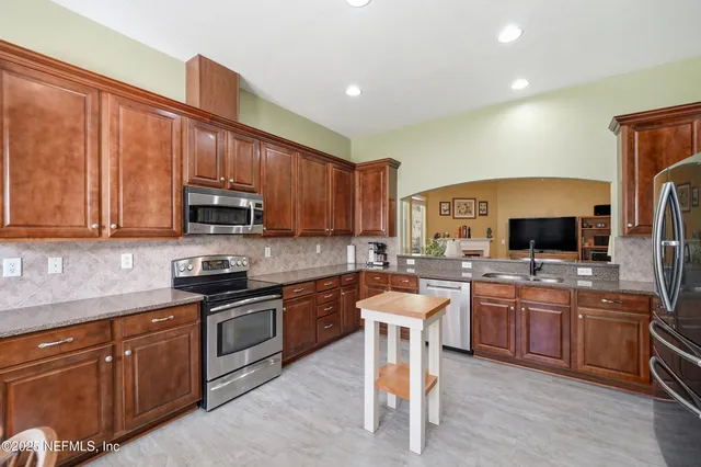 a kitchen with lots of counter top space appliances and cabinets
