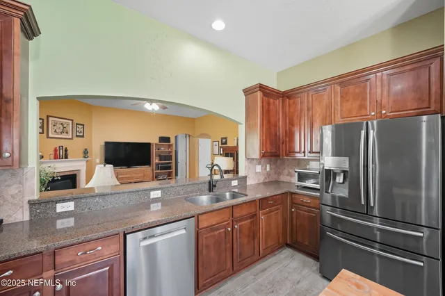 a kitchen with stainless steel appliances a refrigerator sink and microwave
