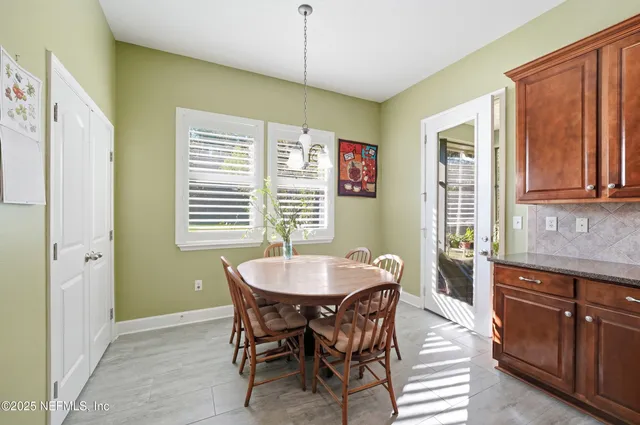 a dining room with wooden floor a chandelier a wooden table and chairs