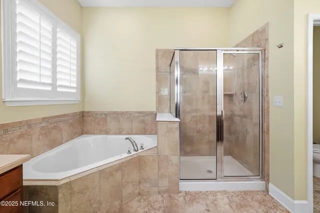 a spacious bathroom with a granite countertop double vanity sink and a mirror