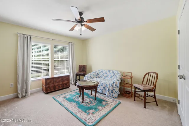 a living room with a table chairs and a large window