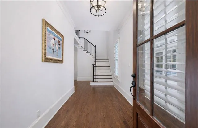 a view of a hallway with wooden floor and staircase