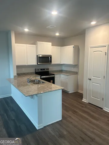 a kitchen with a sink a stove a refrigerator and a microwave