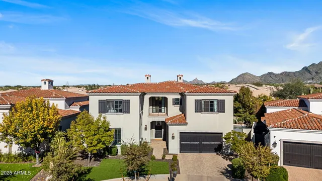 a front view of a house with a yard and mountain view