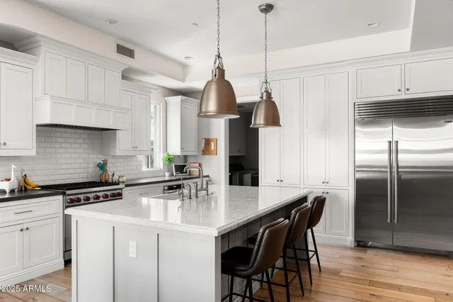 a kitchen with stainless steel appliances a sink a stove a refrigerator and cabinets