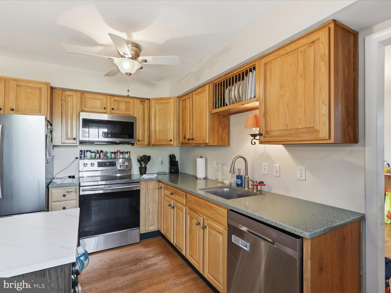 11130 Chapel Road Fairfax Station, VA 22039 - Photo 9 of 55 a kitchen with stainless steel appliances granite countertop a sink dishwasher stove and refrigerator with wooden cabinets