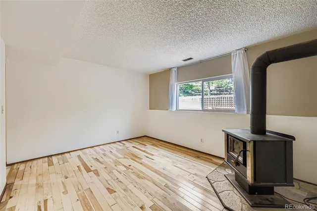 a view of a bedroom with wooden floor and a window