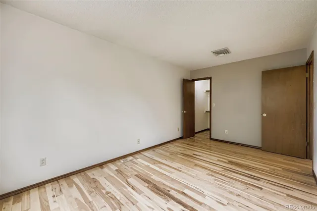 a view of an empty room with wooden floor