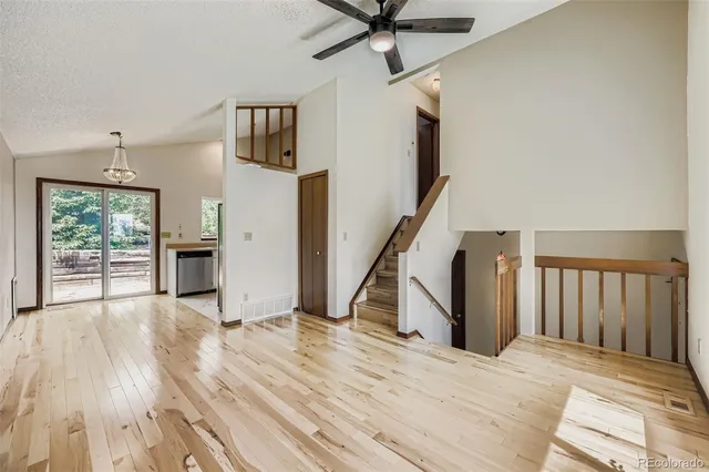 a view of a hallway with wooden floor and staircase