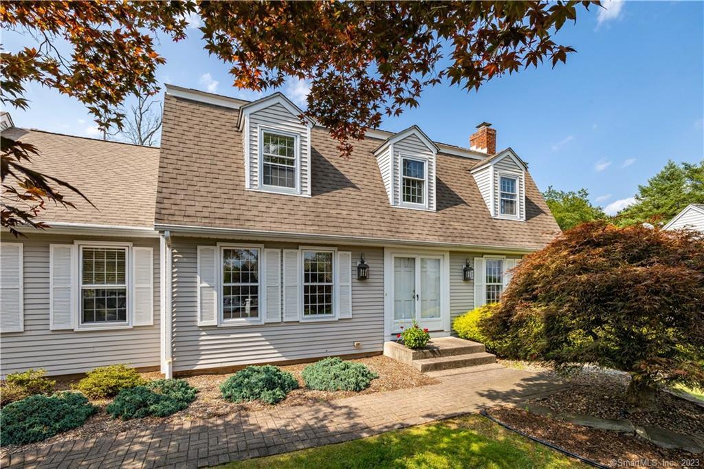 a front view of a house with a yard and potted plants