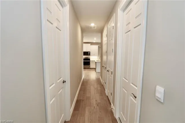 a view of a hallway with wooden floor and staircase