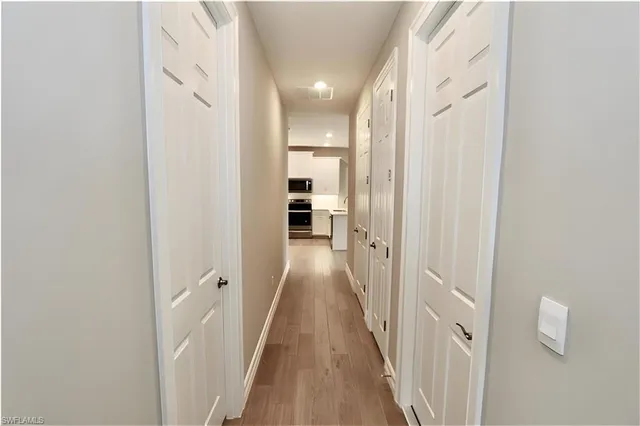 a view of a hallway with wooden floor and staircase