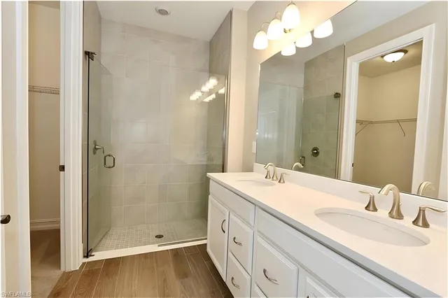 a bathroom with a double vanity sink mirror and shower