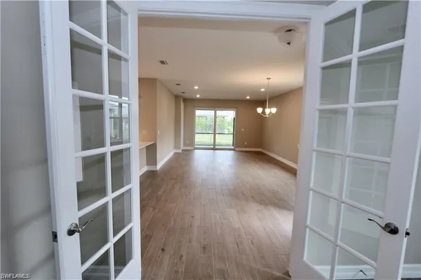 a view of a hallway with wooden floor and closet