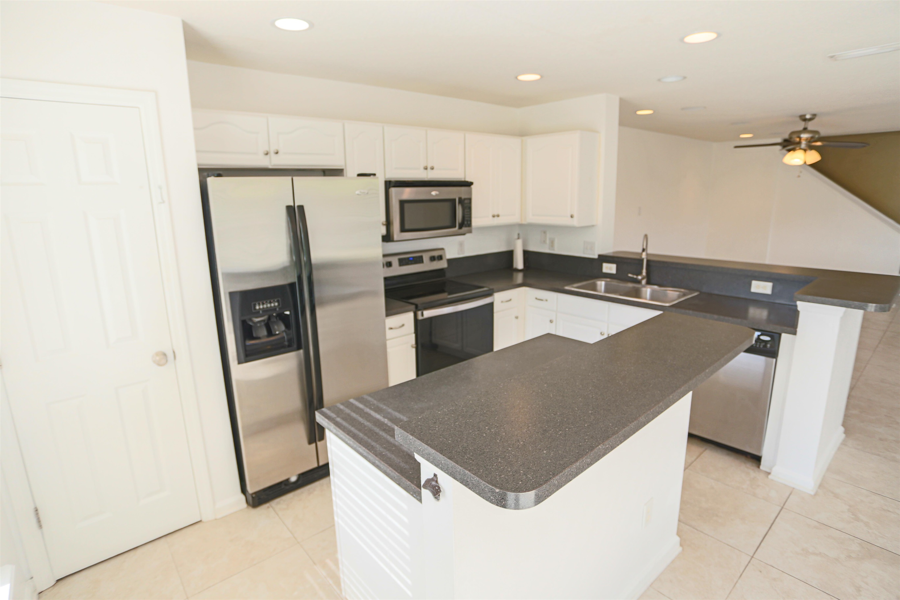 104 Crete Court St. Augustine, FL 32084 - Photo 12 of 32 a kitchen with granite countertop a refrigerator a sink a stove a microwave and island