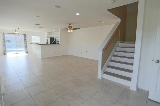 a view of a hallway with stairs and a cabinet