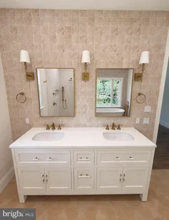 a bathroom with a double vanity sink a mirror and a bathtub