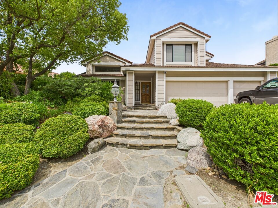 a view of house with garden and entryway