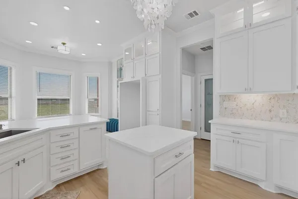 a kitchen with white cabinets and sink