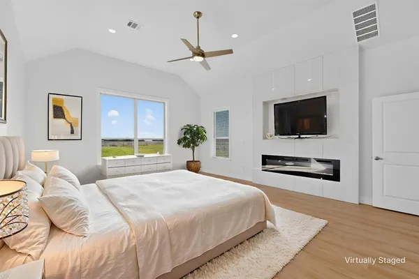 a spacious bedroom with a bed and a flat screen television