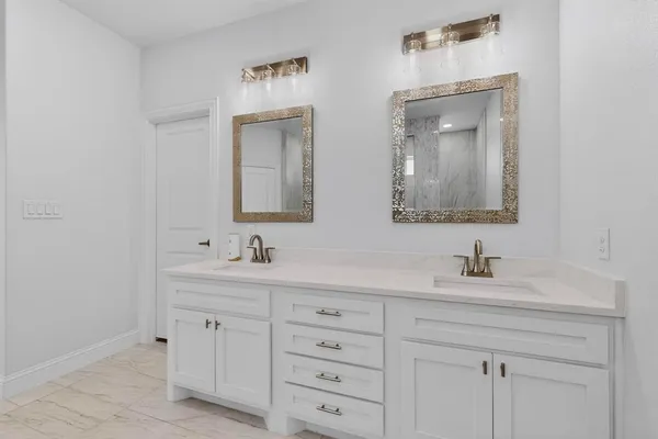 a bathroom with double vanity sinks and a mirror
