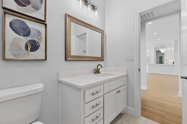 a bathroom with a toilet sink and mirror