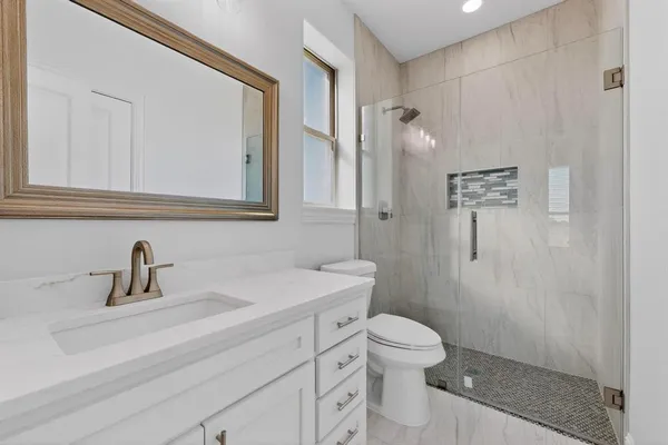 a bathroom with a sink a toilet and shower