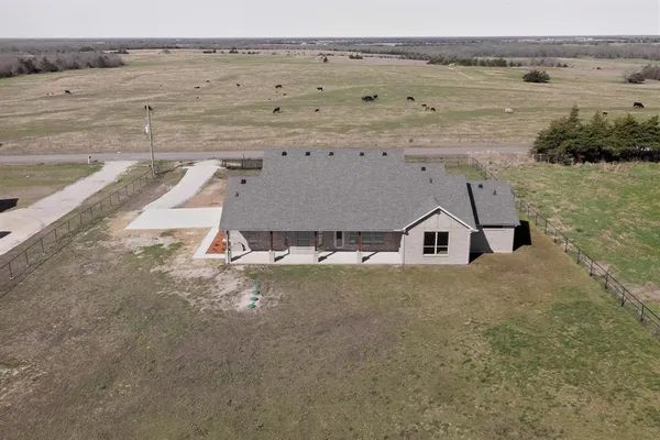 an aerial view of a house with a yard and ocean view
