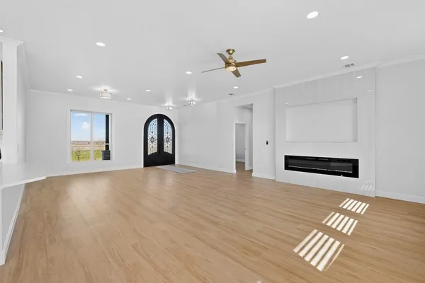 a view of empty room with wooden floor and window