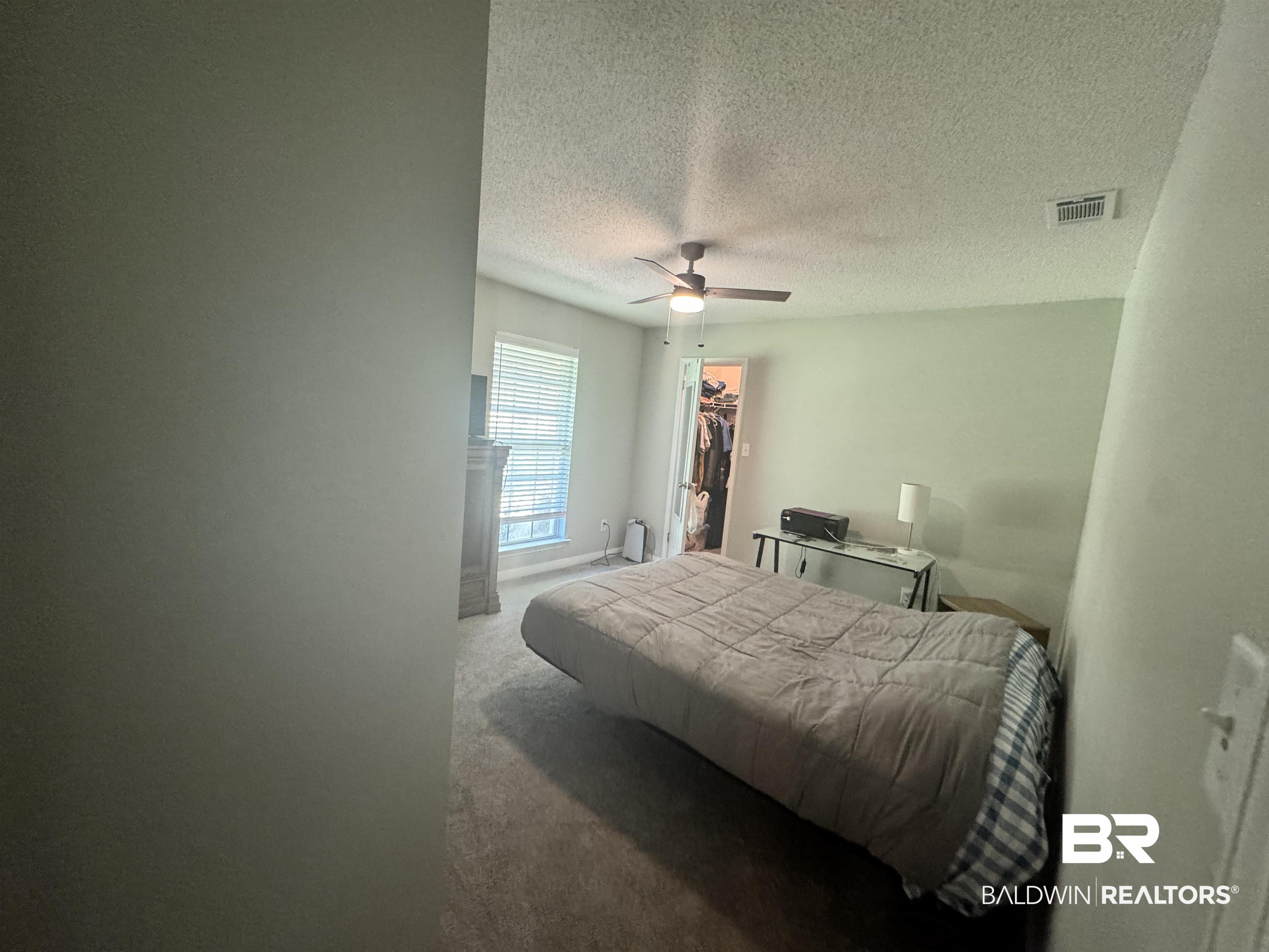 14313 Hemley Road Coden, AL 36523 - Photo 13 of 44 Bedroom with a closet, carpet floors, a spacious closet, a textured ceiling, and ceiling fan