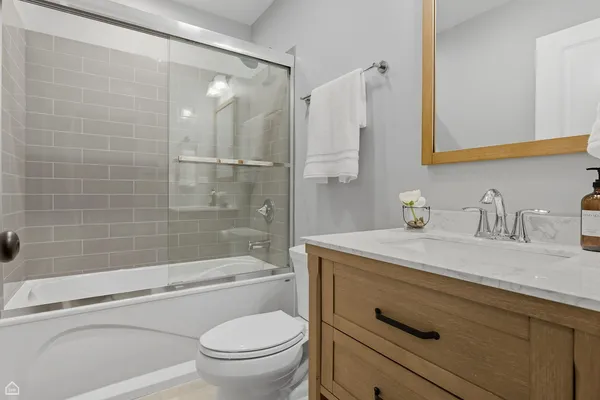 a bathroom with a granite countertop sink a toilet and shower
