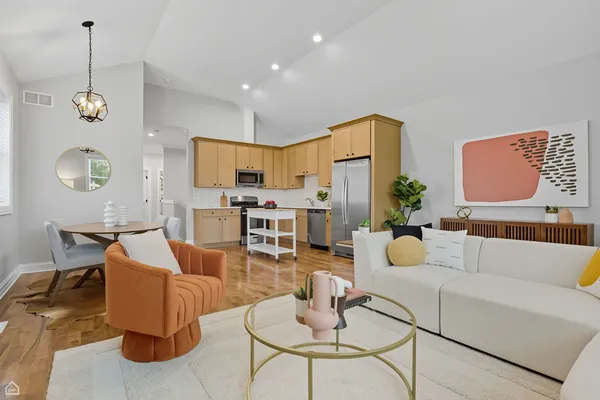 a living room with furniture kitchen view and a chandelier