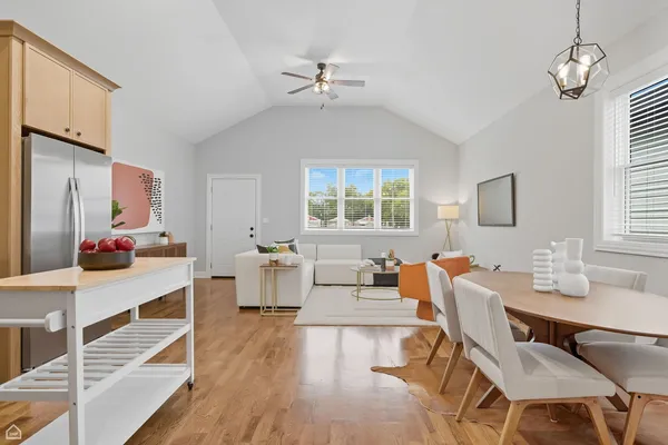 a living room with furniture two window and wooden floor