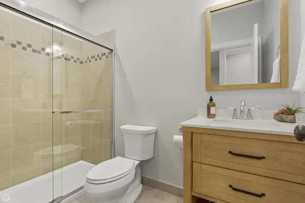 a bathroom with a granite countertop sink toilet a mirror and shower