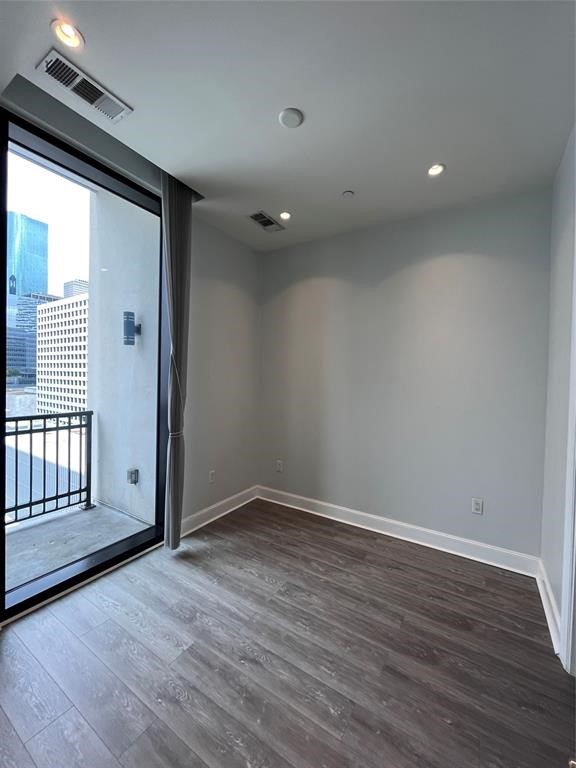 1211 Caroline Street, Unit 1708 Houston, TX 77002 - Photo 13 of 30 a view of an empty room with wooden floor and a window