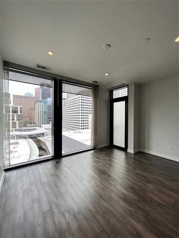 1211 Caroline Street, Unit 1708 Houston, TX 77002 - Photo 17 of 30 a view of an empty room with a window and wooden floor