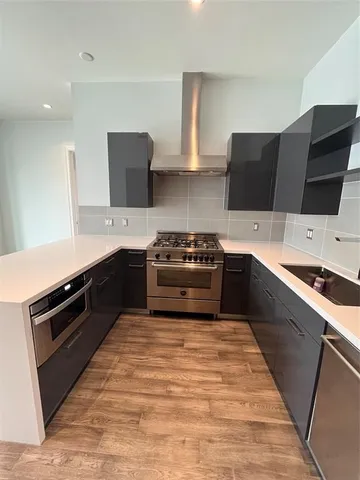 a kitchen with stainless steel appliances kitchen island granite countertop a refrigerator and a sink