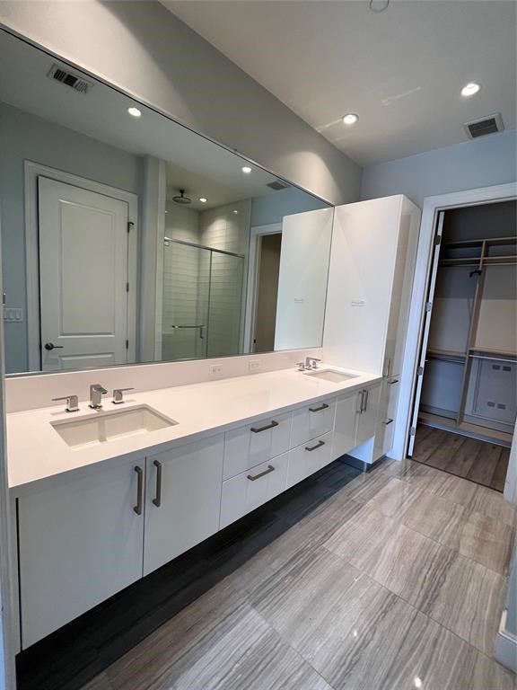 1211 Caroline Street, Unit 1708 Houston, TX 77002 - Photo 25 of 30 a bathroom with a double vanity sink and mirror