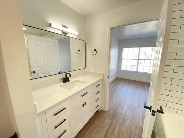 a bathroom with a sink a mirror and a shower