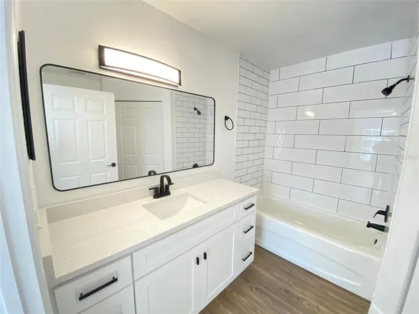 a bathroom with a bathtub a sink a vanity and a shower