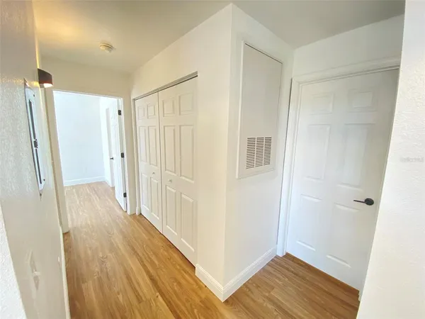 a view of a hallway with wooden floor and staircase