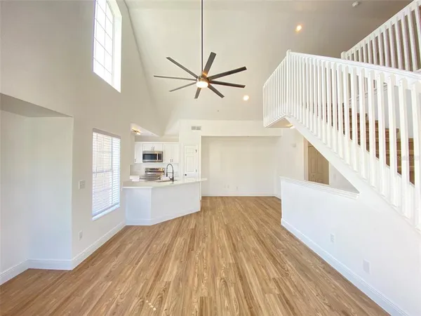 a view of a kitchen with wooden floor and a kitchen space with a sink