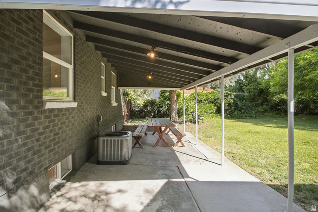 1187 East Ridgedale Circle Millcreek, UT 84106 - Photo 31 of 49 Expansive covered patio featuring a concrete surface, supported by white metal posts, and equipped with overhead lighting