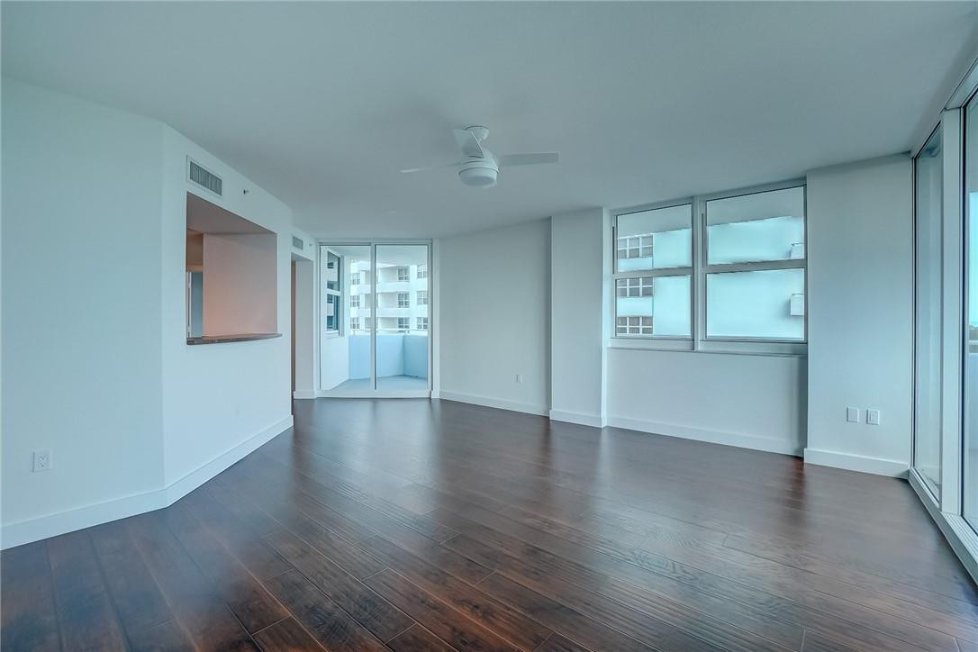 9201 Collins Avenue, Unit 326 Surfside, FL 33154 - Photo 12 of 41 an empty room with wooden floor and windows