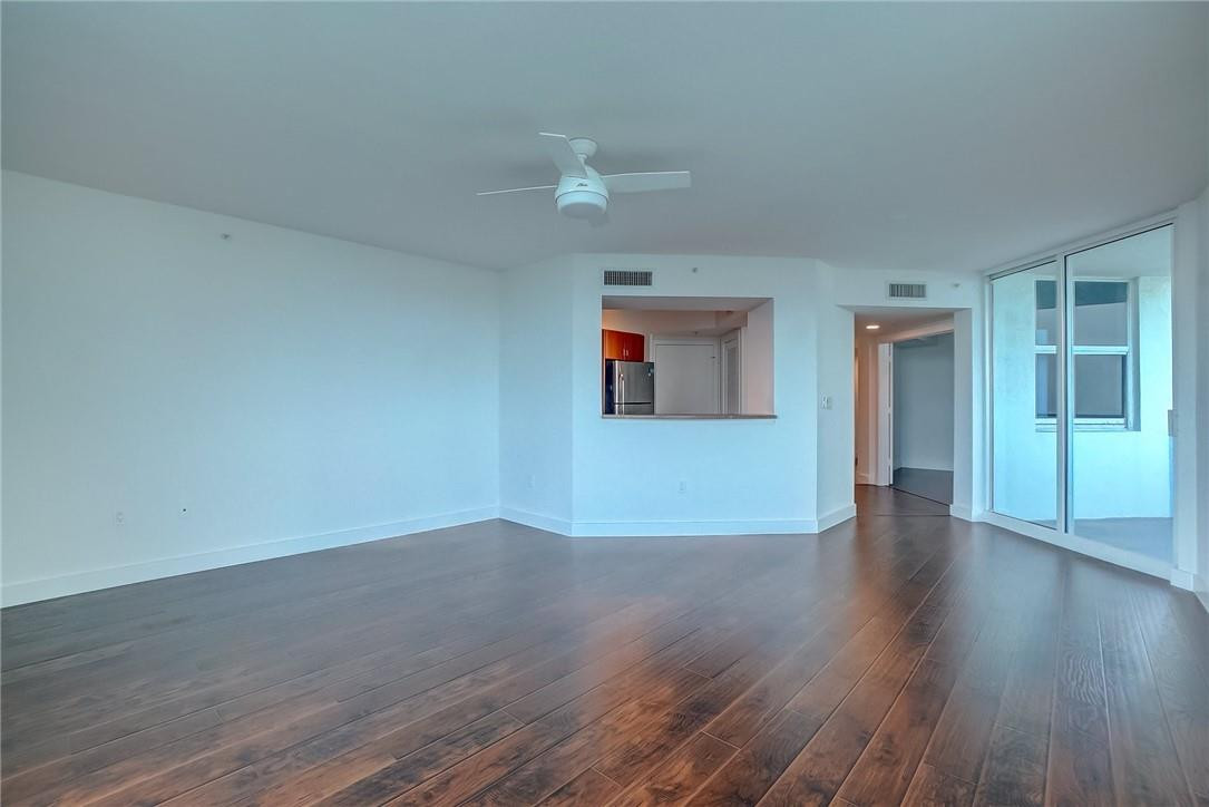 9201 Collins Avenue, Unit 326 Surfside, FL 33154 - Photo 13 of 41 a view of an empty room with wooden floor and a ceiling fan