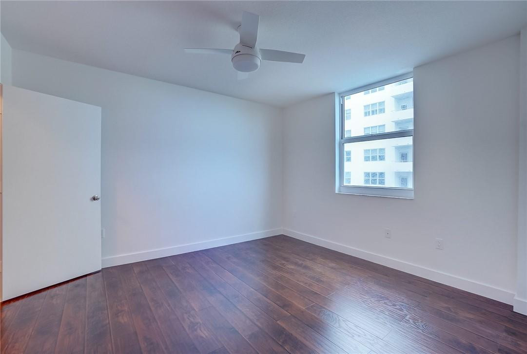 9201 Collins Avenue, Unit 326 Surfside, FL 33154 - Photo 17 of 41 an empty room with wooden floor and windows