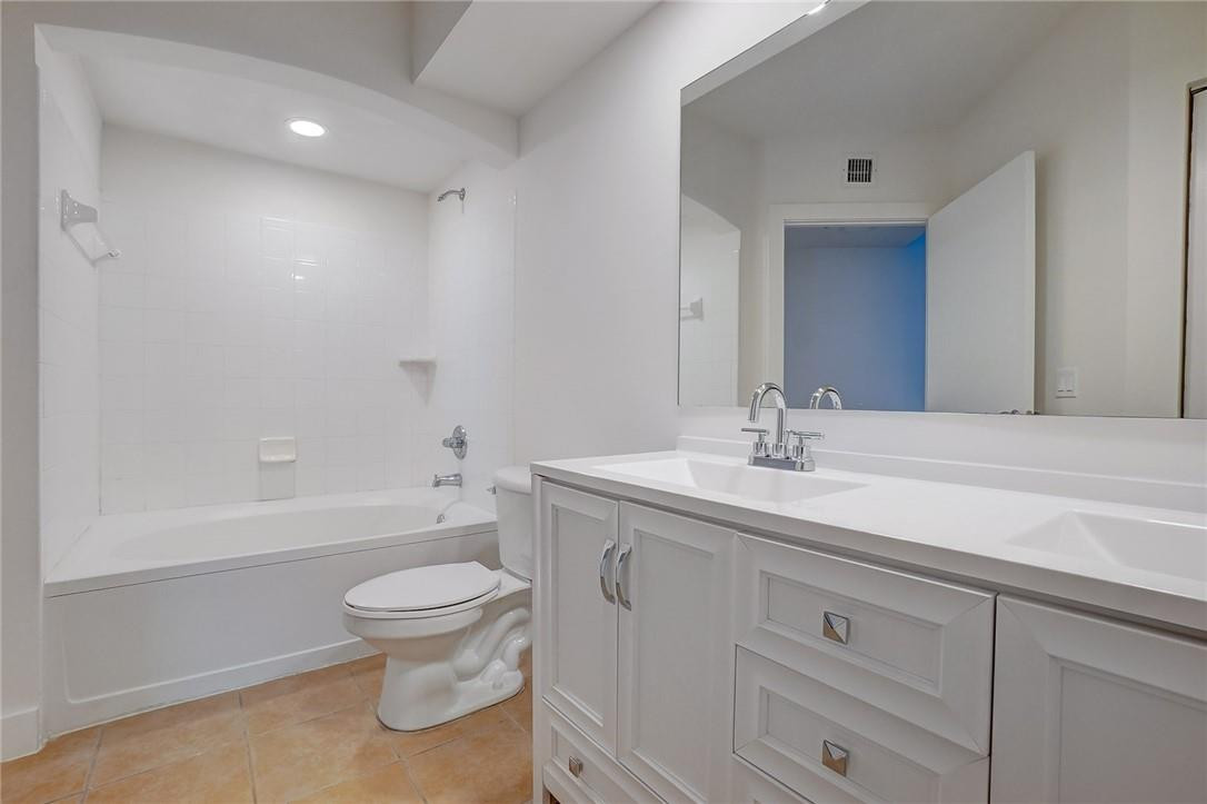 9201 Collins Avenue, Unit 326 Surfside, FL 33154 - Photo 22 of 41 a bathroom with a toilet a sink a mirror a bathtub and vanity